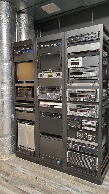 A professional server and broadcast equipment rack setup in a room.