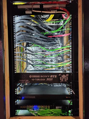 Organized professional audio-visual equipment rack with cables and devices.