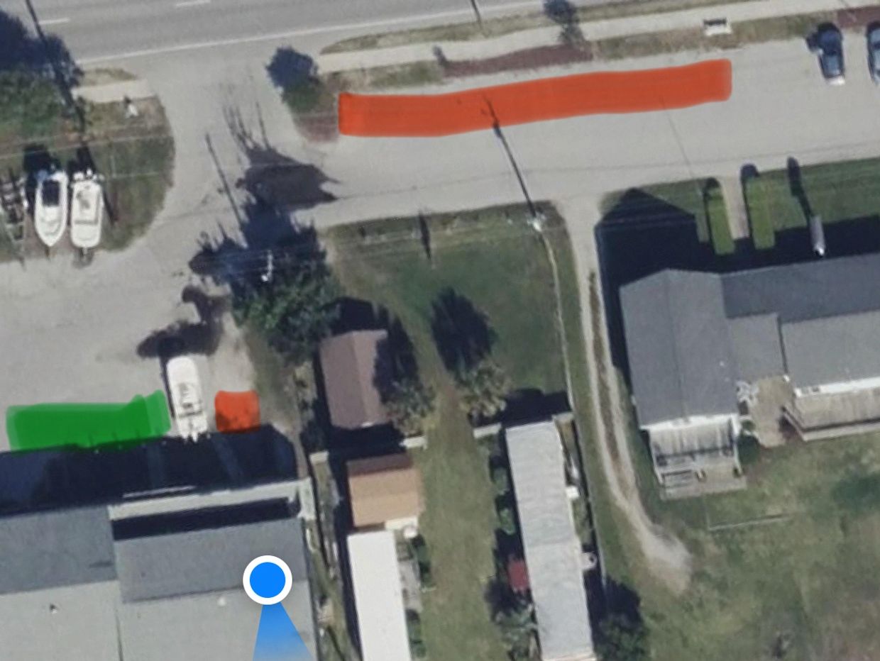 Aerial view of a street with marked zones in red and green.