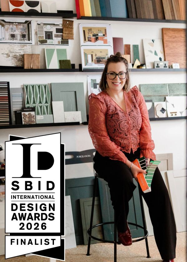 Smiling designer holding color samples, SBID Design Awards 2026 finalist.
