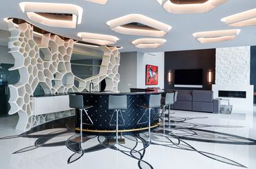 Modern living space with unique honeycomb shelving and stylish bar seating.