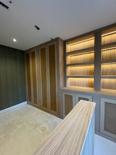 Modern room with wooden shelves and cabinets under construction.