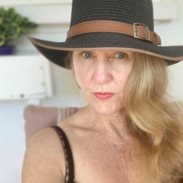 Woman wearing a black hat with a brown strap.