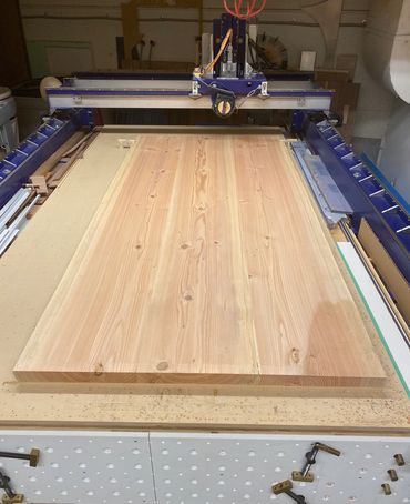 A large Fir tabletop being levelled on Hexisgood's CNC router.