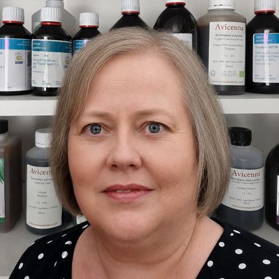 Herbalist standing in front of some bottles of tincture