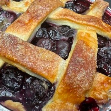Close-up of a blueberry pie with a golden lattice crust.