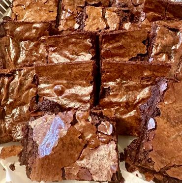 Close-up of freshly baked chocolate brownies with a shiny, cracked top.