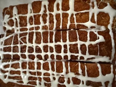 Close-up of a baked pastry with white icing drizzled on top.