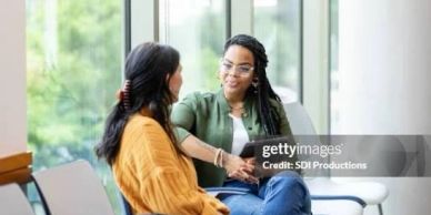 Two women having a conversation indoors.