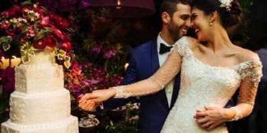 Bride and groom cutting wedding cake together.