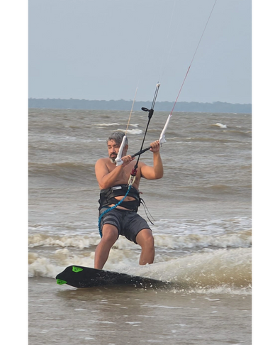 Man kiteboarding on choppy ocean waves.