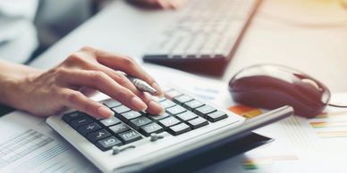 A photograph of a person making estimates on a calculator