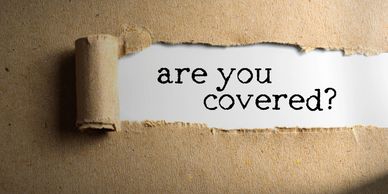 A tear away piece of brown paper revealing the statement "Are you covered?" on white below