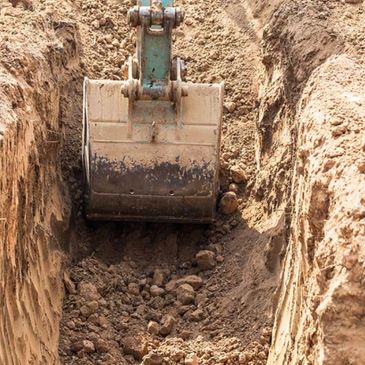 Excavator digging a trench for utilities in Columbus Ohio area.