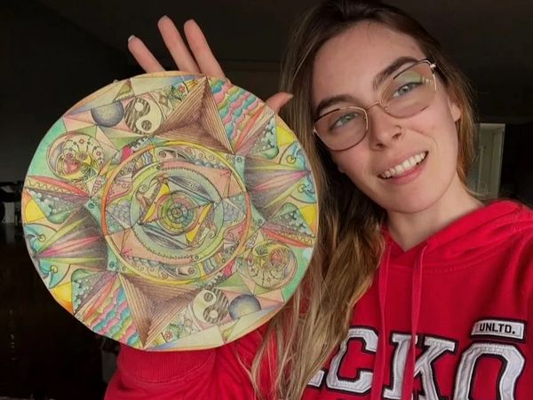 Woman holding a colorful, circular abstract drawing.