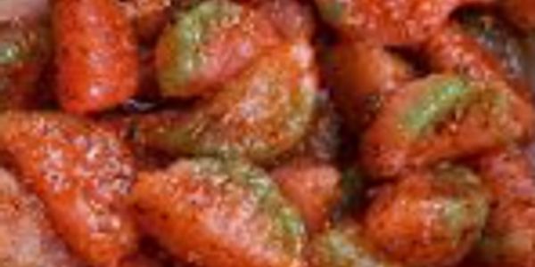 Close-up of seasoned, cooked shrimp with a reddish-orange coating.