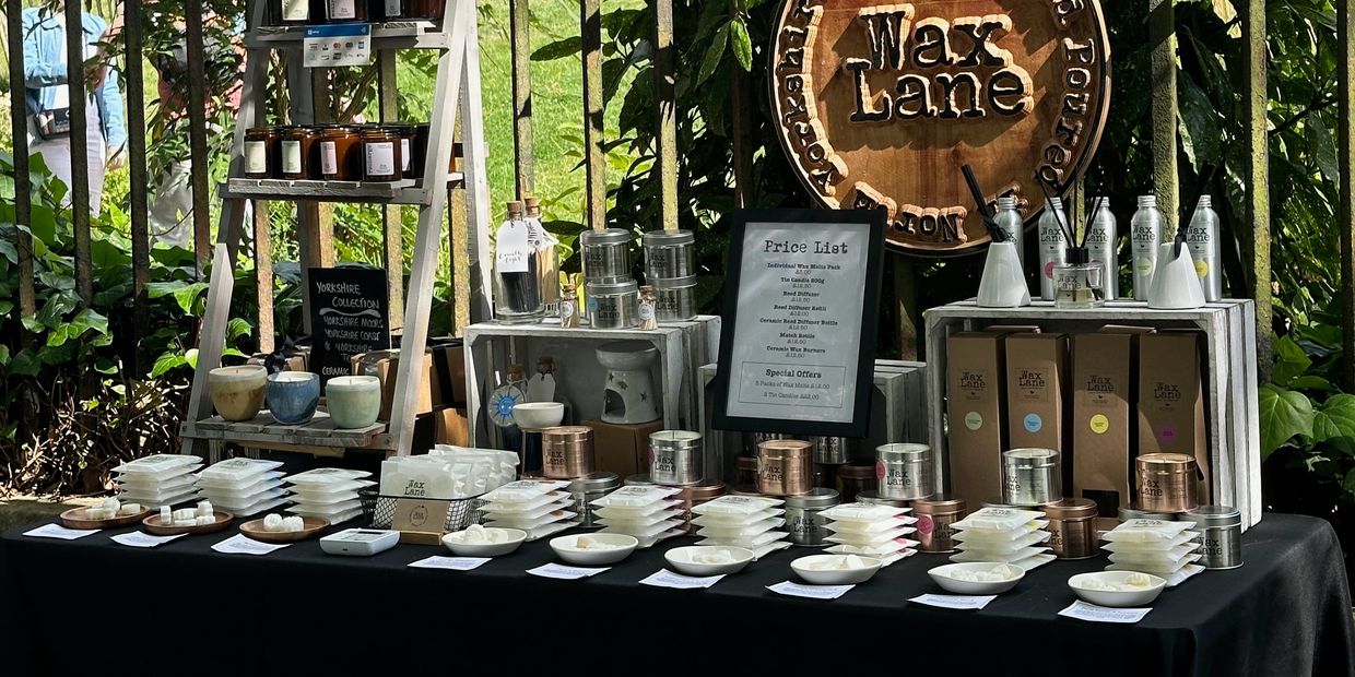 Display table of wax products with price list and Yorkshire collection signage.