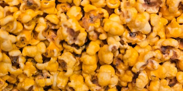 Close-up of cheesy popcorn in a container.