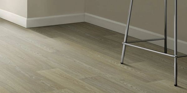 Modern room corner with light wood flooring and a white chair with metal legs.