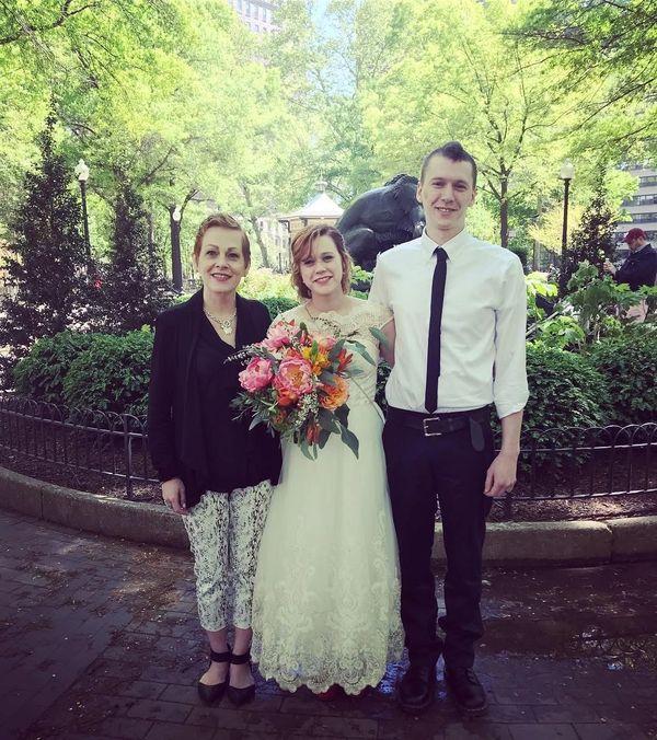 The newlyweds in Rittenhouse Square pose with their officiant after the wedding ceremony.