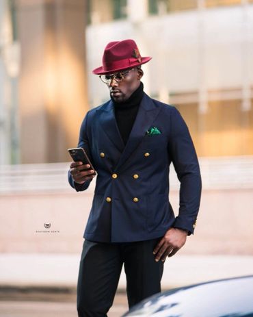 Navy blue double breasted blazer black turtleneck black dress pants burgundy hat green hankie
