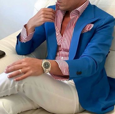 Men's blue blazer with red and white striped dress shirt with matching hanky and white pants