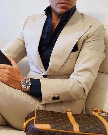 Men's custom made tan suit black dress shirt black hankie Louis Vuitton bag Rolex watch