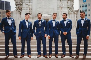 Groomsman's blue suits. blue tuxedos blue bow ties brown shoes. white dress shirts.