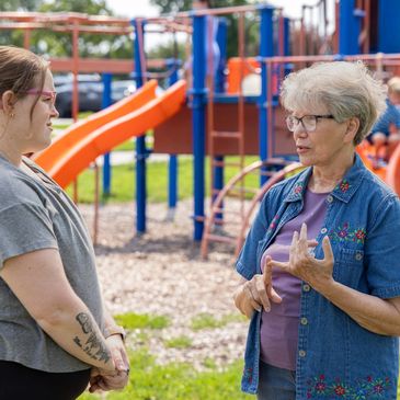 Two women talking in a playground.