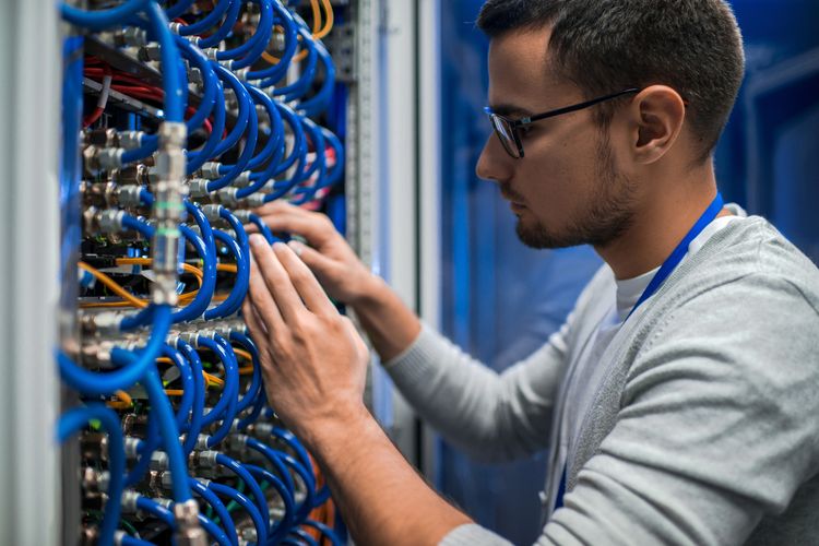 IT technician working on an equipment rack.