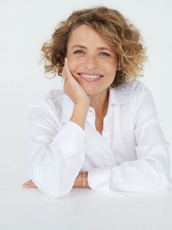 Profil Foto af Katrine Zobel. Smiler autentisk og er glad. Hvid skjorte. Krøllet Hår.