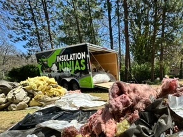 Professional insulation cleanup after removing old damaged attic materials.