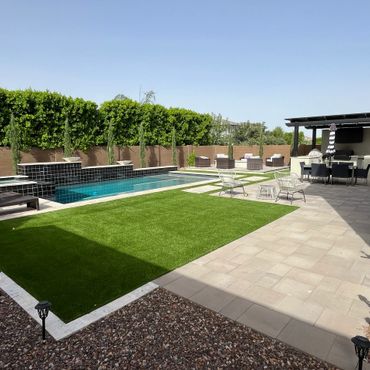 Modern backyard with pool, lounge chairs, and outdoor dining area under a pergola.
