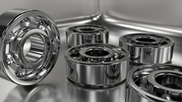 Close-up of shiny metal ball bearings on a reflective surface.