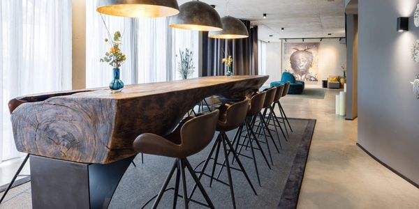 location of dining table and many chairs with art in the background