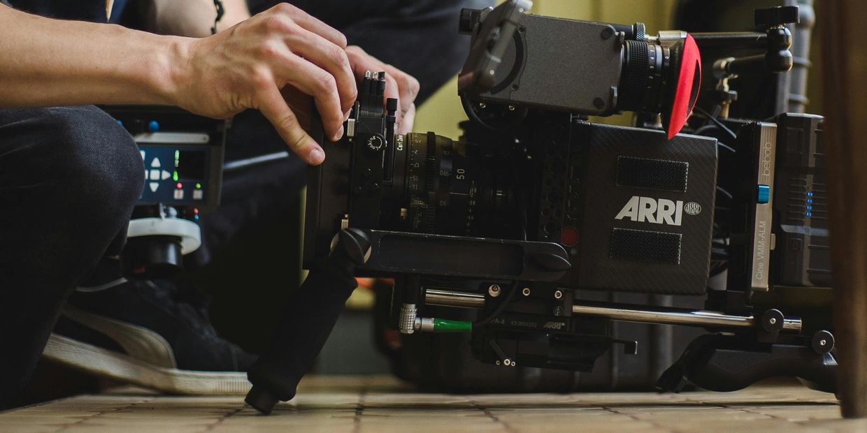 close up of a man adjusting settings on high end video camera
