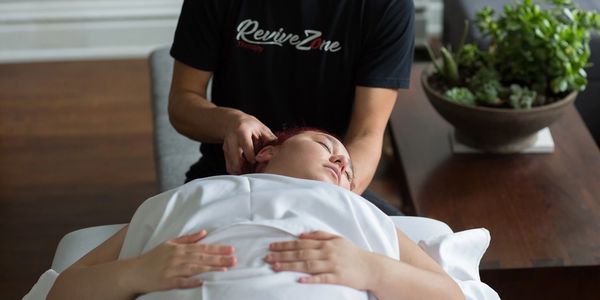 Revive Zone therapist is giving a neck massage