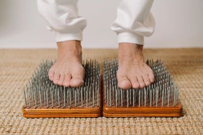 Bare feet standing on boards with sharp metal spikes.