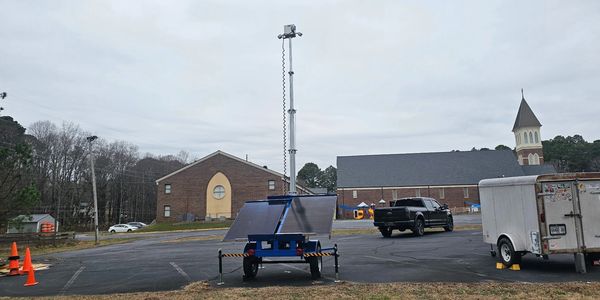 Mobile surveillance trailer unit in parking lot of church facility.