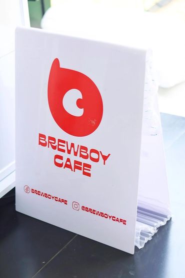 Brewboy Cafe menu stand with logos and social media handles.