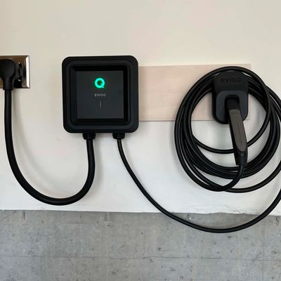 EV100 electric vehicle charger mounted on wall.
