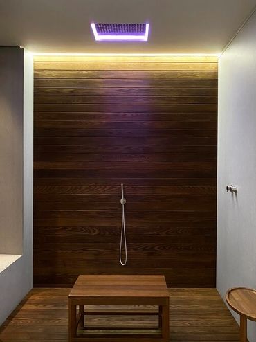 Dark brown wood plank wall with wood floor and table in the foreground, and white walls to the sides