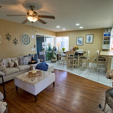 Cozy living and dining area with beige walls, wooden floor, and comfortable seating.