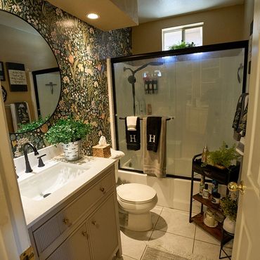 Cozy bathroom with floral wallpaper and modern fixtures.