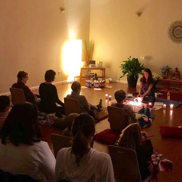 A group meditation session with candlelight in a serene room.