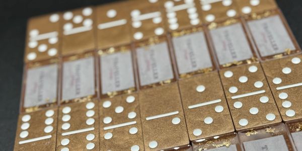 Set of gold-colored dominoes with white dots and 'Traveller' labels.