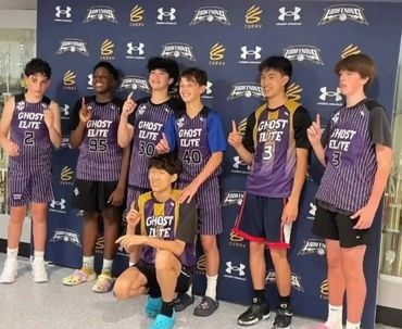 Youth basketball team posing with number one gestures in Ghost Elite uniforms.