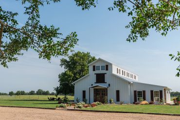 Elegant and rustic white barn venue with stained wood accents