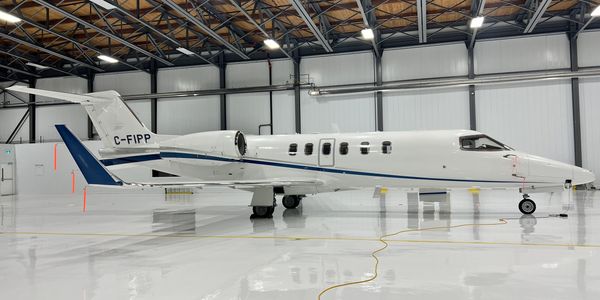 Private jet parked inside a spacious, well-lit hangar.