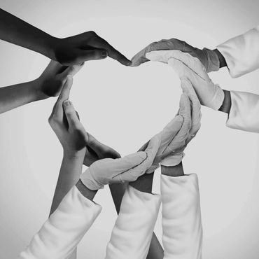 Hands forming a heart shape, some wearing medical gloves and sleeves.